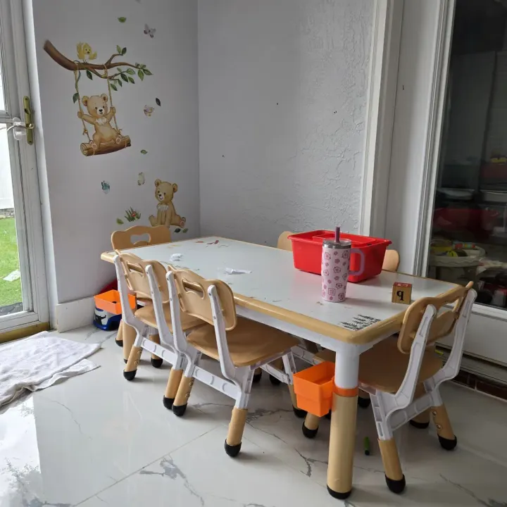 Activity table set up for crafts, with storage bins and playroom wall decor